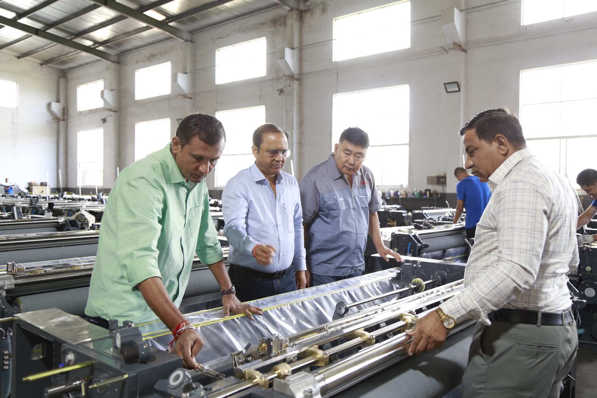 Harmony Impex China Tour 2026 - Customer Machine Inspection. A customer inspecting textile machinery.